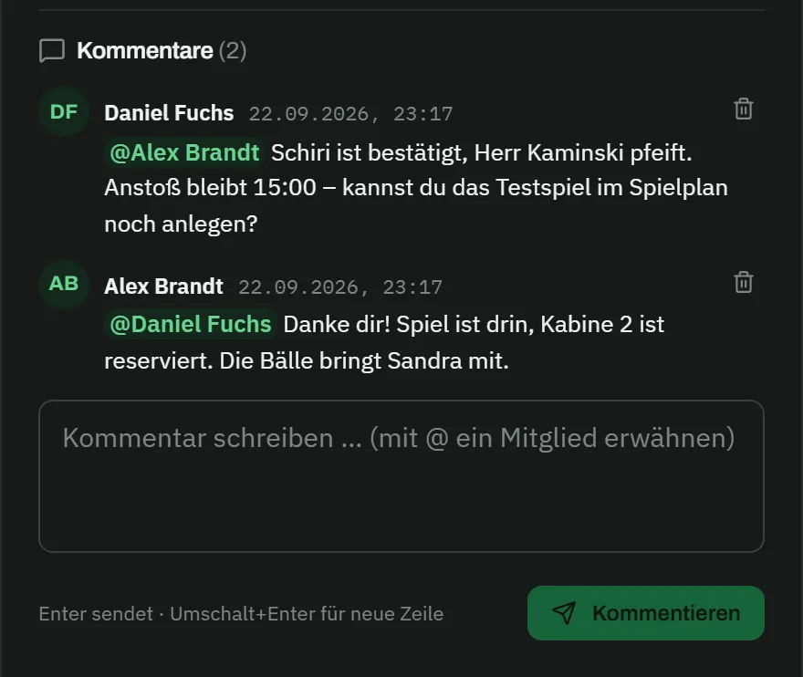 Kommentare zu einer Aufgabe: Daniel Fuchs schreibt an @Alex Brandt, der Schiri sei bestätigt, Herr Kaminski pfeife, Anstoß bleibe 15:00, ob er das Testspiel im Spielplan noch anlegen könne; Alex Brandt antwortet @Daniel Fuchs, das Spiel sei drin, Kabine 2 reserviert, die Bälle bringe Sandra mit; darunter das Eingabefeld „Kommentar schreiben … (mit @ ein Mitglied erwähnen)"